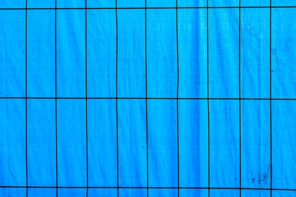 Pozadí Modré Plastové Fólie Kovovou Mřížkou Popředí Ochranu Staveniště — Stock fotografie