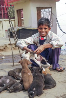 Varanasi, Hindistan - 10 Aralık 2009: Çocuk Hindistan 'ın Varanasi şehrinde genç köpek satıyor. Hindistan 'da köpek eti yenir..