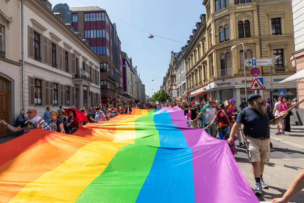 Wiesbaden, Germany - May 27, 2023: people enjoy the christopher street parade in Wiesbaden with rainbow flags and beaufiful costumes.