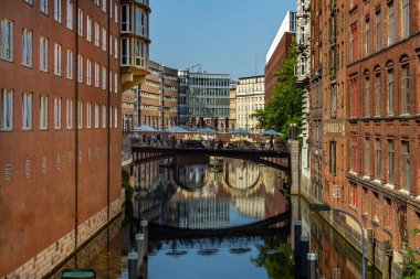 Hamburg, Almanya - 25 Temmuz 2012: Unesco dünya mirası Speicherstadt 'ın bir parçası olan Hamburg' daki Alsterfleet 'deki tuğla evler ve köprünün yansıması.