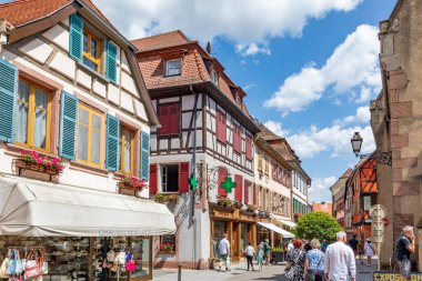 Ribeauville, Fransa - 23 Haziran 2023: Ribeauville, Alsace bölgesindeki Ribeauville köyünde yarım ahşap binalar ve kafeler bulunan pitoresk renkli bir sokak.