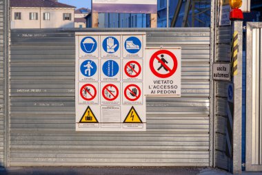 Verona, İtalya - 4 Ağustos 2009: Bir inşaat sahasına nasıl güvenlik getirileceğine dair tabelalarla krom kaplama duvarı, uyarı işaretleri.