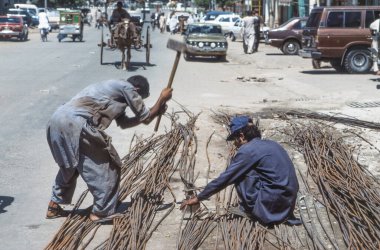 Peşaver, Pakistan - 30 Haziran 1987: sokak işçisi sıva stabilizasyonu için bir ızgara oluşturmak için demir çubuklar hazırlayın.