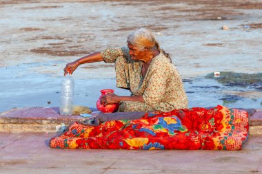 Delhi, Hindistan - 17 Kasım 2011: Yaşlı kadın Delhi, Hindistan 'daki Meena Çarşısı' nda bir şişe suyla dinleniyor. Şah Cihan 17. yüzyılda İsfahan Çarşısı 'ndan esinlenerek çarşıyı kurdu..