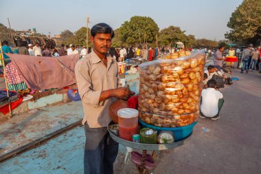 Delhi, Hindistan - 17 Kasım 2011: Sokak işportacısı halka şekerli içecek ve patates satıyor.,
