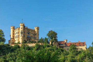 Almanya 'daki Hohenschwangau Kalesi. Schloss Hohenschwangau, Bavyera Alpleri 'nin ünlü simgesidir. Eski Alman kalesinin manzarası, yazın Münih yakınlarındaki Kral II. Ludwig 'in sarayı..