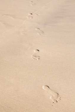 Kum üzerinde insan ayak izi. Kopyalama alanı olan tropikal plaj arka planı..