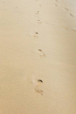 Kum üzerinde insan ayak izi. Kopyalama alanı olan tropikal plaj arka planı..