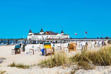 Ahlbeck, Almanya - 20 Nisan 2014: insanlar iskele ve Plajı Ahlbeck, Almanya tadını çıkarın. Baltık Denizi Usedom adasında kendi benzersiz çatılı hasır sandalye için ünlüdür.