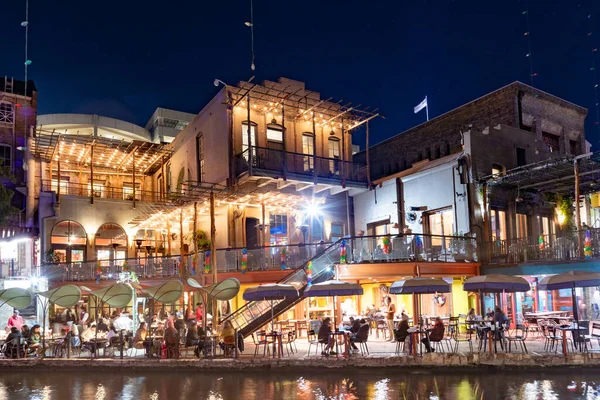 San Antonio, ABD - 31 Ekim 2023: İnsanlar San Antonio Nehri Yürüyüşü 'nde gece kostümleri ve aydınlatılmış ağaç ve restoranlarla eğleniyor..