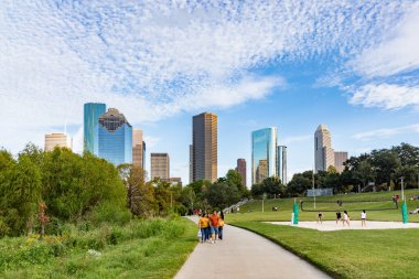 Houston, ABD - 22 Ekim 2023: İnsanlar Buffalo Bayou Parkı 'ndan sabah güneşiyle Houston, Teksas' ın ufuk çizgisine manzaranın tadını çıkarıyorlar. Bazıları voleybol oynar.