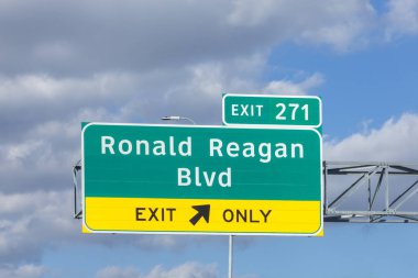 Ronald Reagan Bulvarı 35 numaralı kavşaktan çıkış. Öğleden sonra güneşli ve bulutlu trafik var.