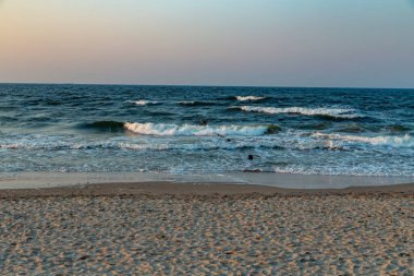 Kullanım alanı, Baltık Denizi 'ndeki kumlu sahilde manzaralı günbatımı