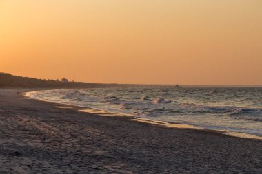 Kullanım alanı, Baltık Denizi 'ndeki kumlu sahilde manzaralı günbatımı