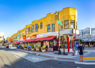 San Francisco, ABD - 18 Mayıs 2022: San Francisco şehir merkezindeki eski evler Stockton, Columbus Caddesi 'ndeki parlak ışık altında.