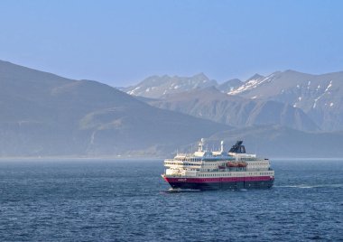 Lofoten, Norveç - 8 Temmuz 2009: Norveç 'te Nordlys yolcu gemisi ve arka planda karlı dağlar.
