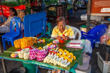 Bangkok, Tayland - 4 Ocak 2010: Erkekler sabahın erken saatlerinde Bangkok 'taki çiçek pazarında çiçek bağlıyor.