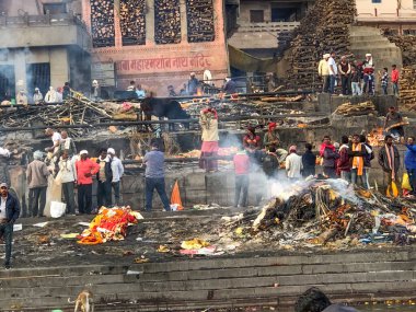 Varanasi, Hindistan - 24 Şubat 2024: Varanasi 'de ölü insanların yakıldığı ve kutsal nehir çetelerinde küllerin çaresizce toplandığı ghatlarda yakma töreni.