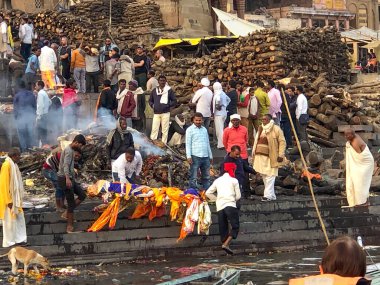 Varanasi, Hindistan - 24 Şubat 2024: Varanasi 'de ölü insanların yakıldığı ve kutsal nehir çetelerinde küllerin çaresizce toplandığı ghatlarda yakma töreni.