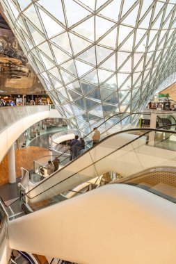Frankfurt, Germany - March 3, 2024: interior view of atrium and escalator hall with  curvature corridor of Myzeil, modern shopping mall in Frankfurt. clipart