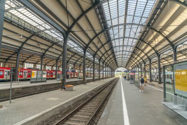 Wiesbaden, Almanya - 15 Mayıs 2024: İnsanlar kırmızı S-Bahn trenleriyle Wiesbaden klasik terminal tren istasyonuna doğru acele ediyorlar..