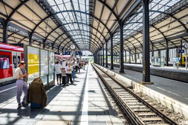 Wiesbaden, Almanya - 27 Mayıs 2024: İnsanlar Wiesbaden 'deki klasik mimari stil ile klasik terminal tren istasyonunda trene acele ediyorlar..