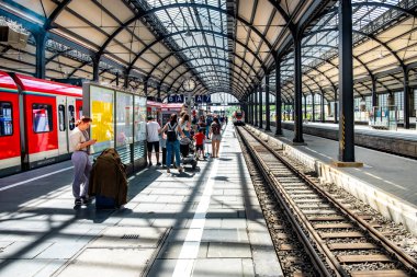 Wiesbaden, Almanya - 27 Mayıs 2024: İnsanlar Wiesbaden 'deki klasik mimari stil ile klasik terminal tren istasyonunda trene acele ediyorlar..