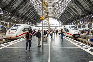 Frankfurt, Germany - May 27, 2024: people hurry to the train in the classicist terminal train Station with typical architectural style of classicism in Frankfurt. clipart