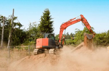 Vinç zeminini sağlamlaştırmak için mineral kum ve çakıllı kürekleri olan bir inşaat alanında kazıcı.