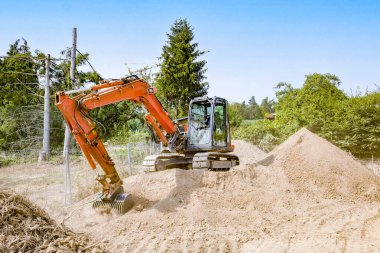 Vinç zeminini sağlamlaştırmak için mineral kum ve çakıllı kürekleri olan bir inşaat alanında kazıcı.