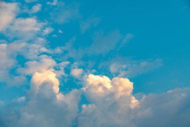 Sabahın erken saatlerinde mavi gökyüzü ve yumuşak beyaz bulutlarla manzaralı.