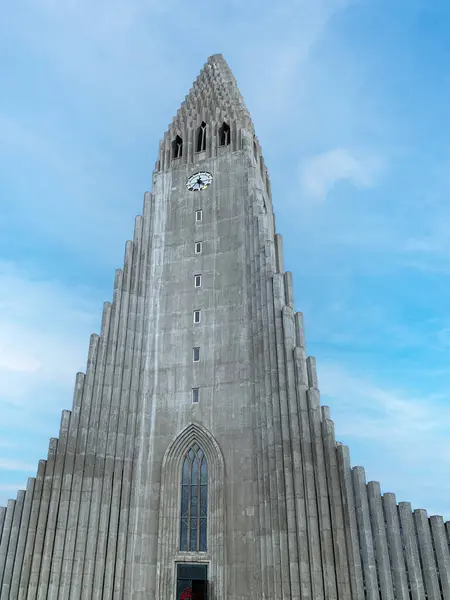 stock image Beautiful Hallgrimskirkja church and statue of explorer in center of Reykjaivk. Grass growing in front of Tallest cathedral against cloudy sky during sunset.