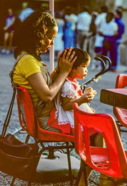 Tel Aviv, İsrail - 9 Eylül 1989: Annesi Tel Aviv 'de bir restoranda otururken çocuğuna bakıyor..