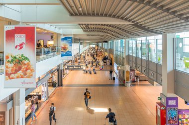 HAMBURG, GERMANY - MAY 18, 2017: People hurry to the gate in Terminal 2  in Hamburg, Germany. Terminal 2 was completed in 1993 and houses Lufthansa and other Star Alliance partners. clipart