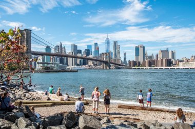 New York, ABD - 10 Ekim 2017: İnsanlar Brooklyn Köprüsü 'nden New York' un ufuk çizgisine kadar olan sahilin tadını çıkarıyorlar..
