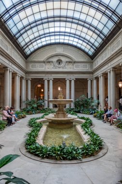 New York, ABD - 10 Ekim 2017: Çelik kralı Henry Clay Frick 'in eski 5. Cadde köşkündeki Frick Koleksiyonu' nun avlusunda dinlenen insanlar.