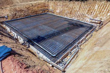 Fischbach, Almanya - 23 Temmuz 2023: Demir çubuğu beton temel ve yalıtım için Pentaflex plastik yalıtım malzemesi ile hazırlamak.