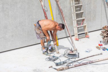 Fischbach, Almanya - 28 Temmuz 2020: inşaat alanında çalışan işçi prefabrik duvarlarla bodrumda beyaz mahzen inşaatı adı verilen su geçirmez betonla hazırlanıyor..