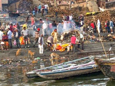 Varanasi, Hindistan - 24 Şubat 2024: İnsanlar Varanasi 'deki nehir çetelerinde yapılacak defin töreni için renkli elbise ve çiçeklerle süslenmiş bir ceset hazırlıyorlar..