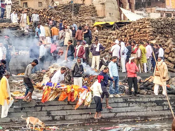 Varanasi, Hindistan - 24 Şubat 2024: Varanasi 'de ölü insanların yakıldığı ve kutsal nehir çetelerinde küllerin çaresizce toplandığı ghatlarda yakma töreni.