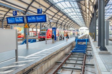 Wiesbaden, Almanya - 22 Ağustos 2024: Wiesbaden, Almanya 'daki tarihi klasik tren istasyonunda tren bekleyen insanlar.