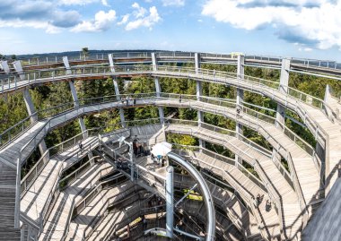 Bad Wildbad, Almanya - 29 Ağustos 2024: Gözlem kulesinde ve ağaç tepesinde yürüyen insanlar - mikrop. Baumwipfelpfad - Kara Orman - mikrop. Schwarzwald.