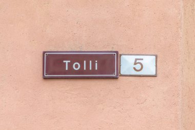 old enamel streetname Tolli 5  in Tallinn, Estonia at an old wall in the old town clipart