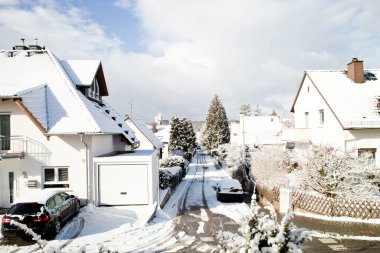 Frankfurt yakınlarında beyaz kar ve mavi bulutlu gökyüzü ile kaplı güzel bir yaşam alanı.
