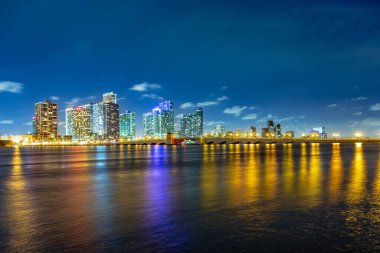 Miami şehir manzarası panorama ile kentsel gökdelenler ve köprüden denize ile yansıma alacakaranlıkta