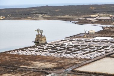 scenic salt mine basins with water mill at Janubio, Lanzarote, Canary islands, Spain clipart