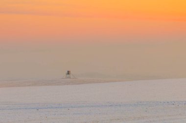 bright winter landscape with snow covered fields and hunter stand clipart