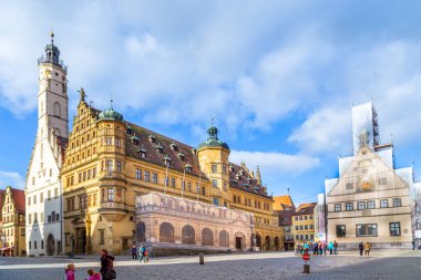 Rothenburg ob der Tauber, Almanya - 15 Ocak 2014: Rothenburg ob der Tauber 'de tarihi belediye binasıyla pazar meydanında turistler. Ortaçağ kasabası her yıl 2 milyondan fazla ziyaretçi çekiyor..