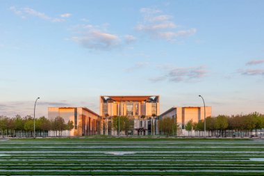 Berlin, Almanya - 3 Mayıs 2015: Bundeskanzleramt (Federal Chancellery Almanca) Sunrise renkli ağaçlar ile. Alman cancellor merkezi olduğunu.