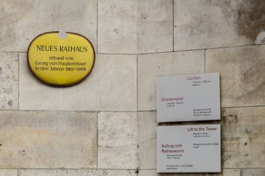 Münih, Almanya - 26 Ekim 2016: Münih 'teki ünlü yeni belediye binasının işareti. Mimar Georg von Hauberrissen binayı 1908 yılında bitirdi. Meşhur Carillon için imza ve sağdaki kule için asansör..